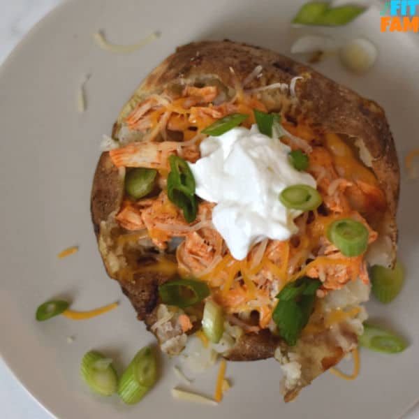 This crIspy skinned buffalo chicken baked potato is a macro friendly meal & is a weekly staple at our house! High protein & topped with Greek yogurt and green onions, this is too good to pass up. #iifym #dietfriendly