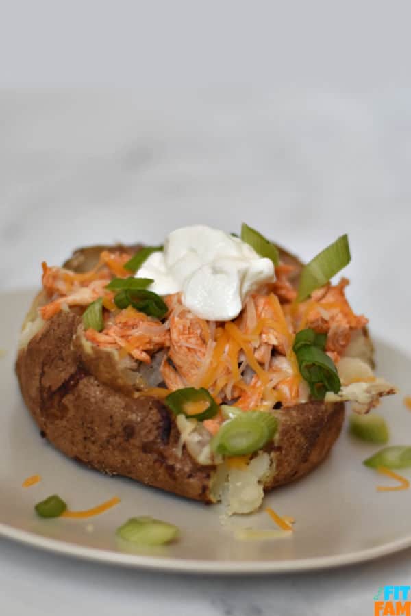 This crIspy skinned buffalo chicken baked potato is a macro friendly meal & is a weekly staple at our house! High protein & topped with Greek yogurt and green onions, this is too good to pass up. #iifym #dietfriendly