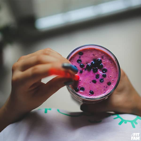 woman holding a berry smoothie