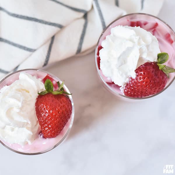 yogurt & jello dessert topped with whipped cream & strawberries