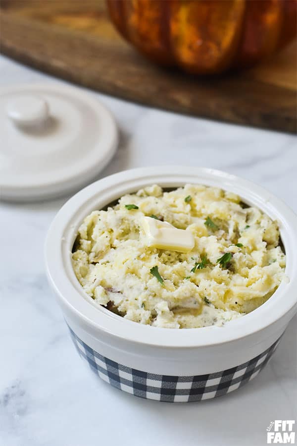 Healthy herb mashed potatoes with mashed cauliflower mixed in. Your kids won't even know they're eating extra veggies! Such a yummy dinner side! Perfect healthy side for Thanksgiving too!