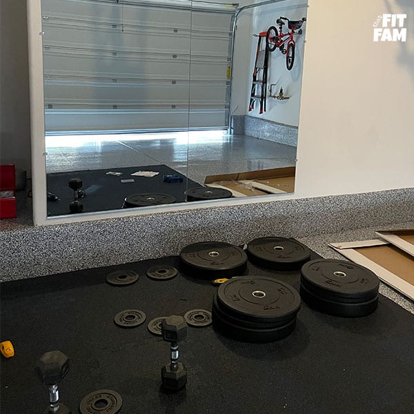 garage gym in progress. gym mirrors and floor mats