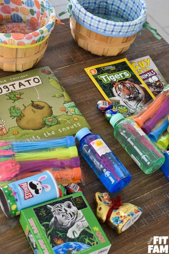 Easter basket haul on table for kids ages 6 & 7. books, water balloons, bubbles, puzzles