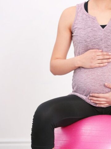 pregnant woman sitting on exercise ball