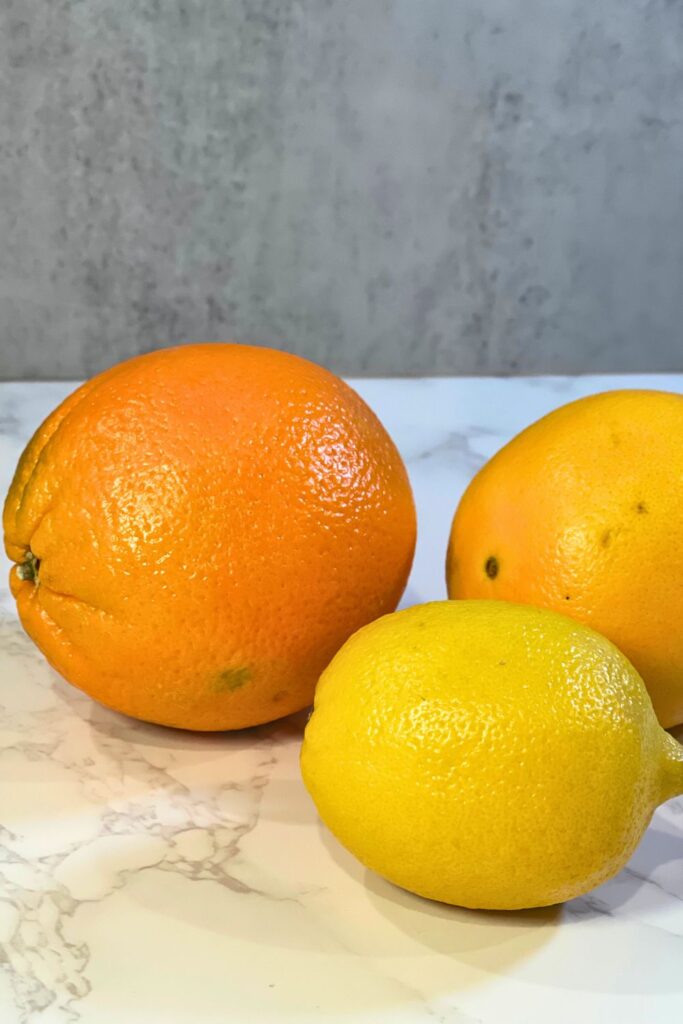 two navel oranges and a lemon, these can be dehydrated in the oven and used for holiday decor.